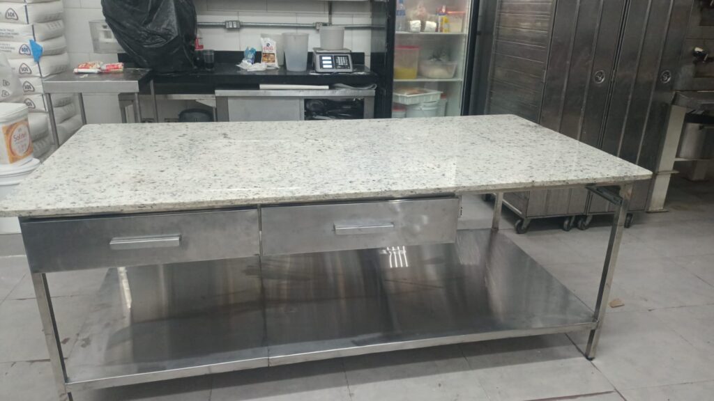 Bancada industrial em aço inoxidável com tampo de granito e gavetas sob medida